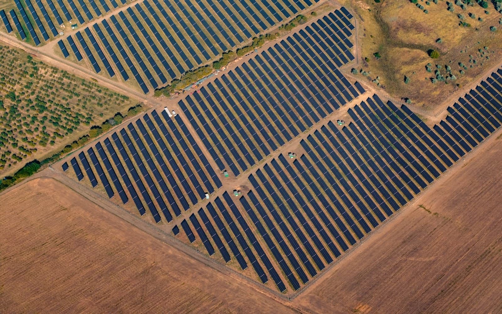 Aerial view of a solar power plant with rows of photovoltaic panels